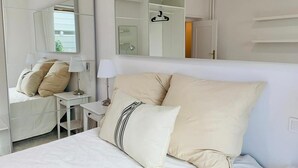 A bedroom with a bed, bedside tables, a mirror, and a wardrobe. - Acogedor piso cerca al Parque El Retiro FREE WIFI (Madrid)