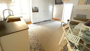 A modern kitchen with white cabinets, a built-in oven, and a large window. - Acogedor piso cerca al Parque El Retiro FREE WIFI (Madrid)