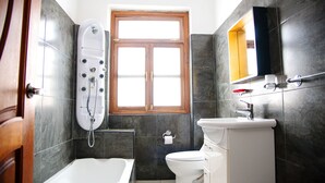 Uma casa de banho com banheira, sanita e cabine de duche.