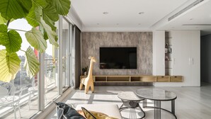 A modern living room with a large TV, a giraffe statue, and a balcony with city views. - 1LI7E HOTEL (Taichung)