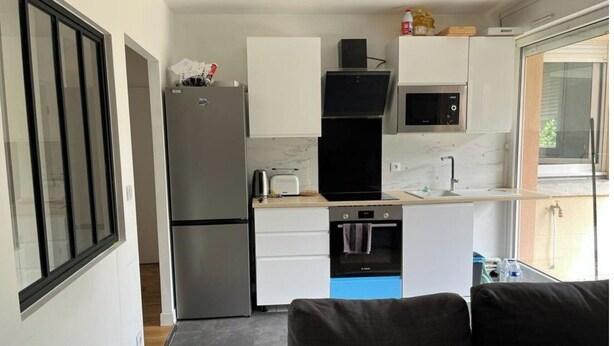 Una cocina compacta equipada con refrigerador, microondas, tostadora y horno.