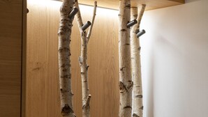 A wooden cabinet with a built-in shelf holding several birch tree branches. - Casera Cal De Mez Sot - Wellness Chalet (Chies d´Alpago)