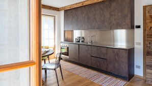 Una cocina moderna con armarios de madera oscura, electrodomésticos de acero inoxidable y techo de madera.