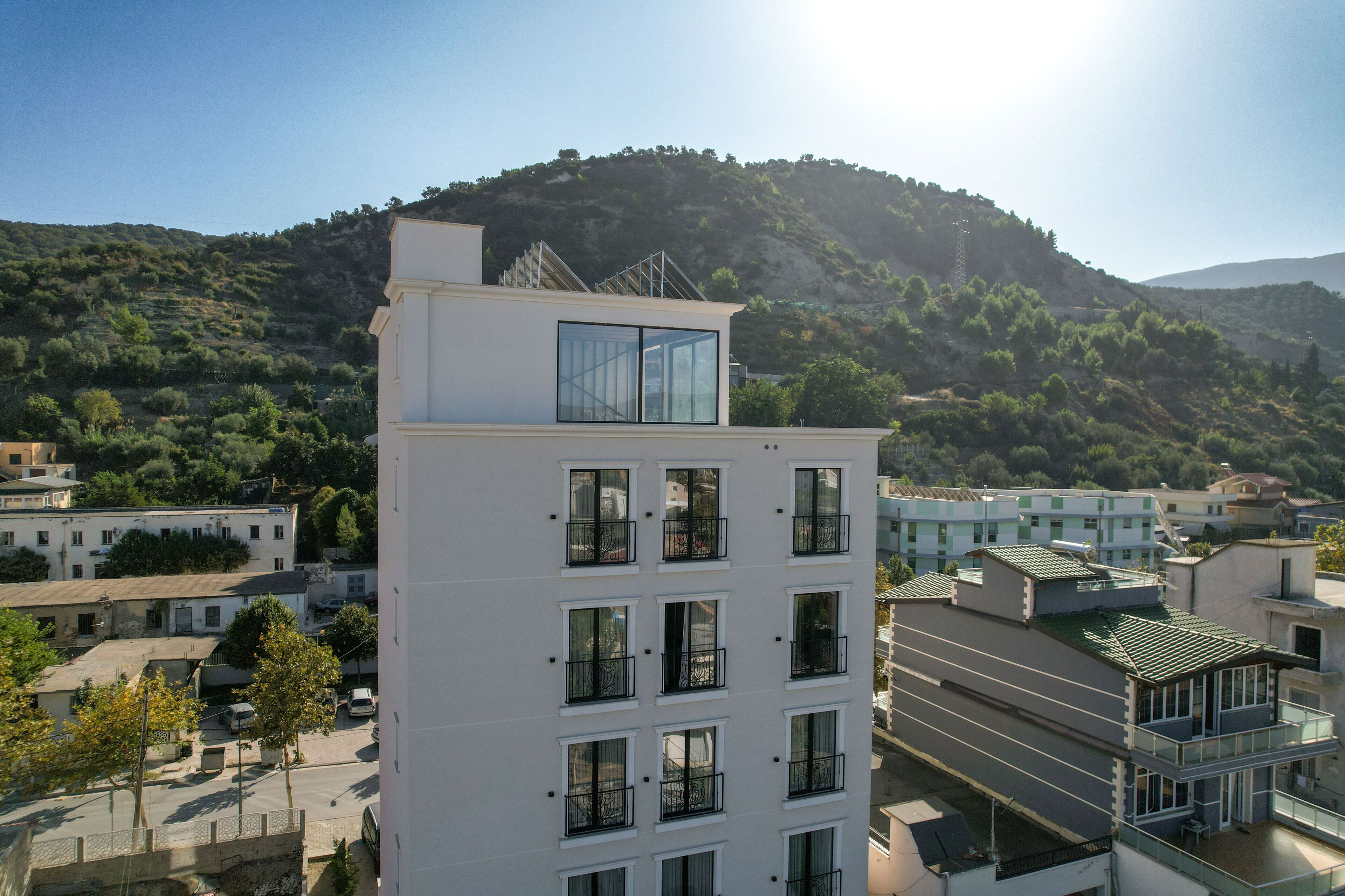 A multi-story building with a flat roof, large windows, and balconies.