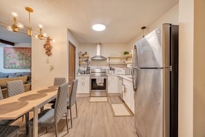 Enjoy cooking in this well-equipped kitchen with a refrigerator, oven, and microwave. Dine at the adjacent table with comfortable chairs.