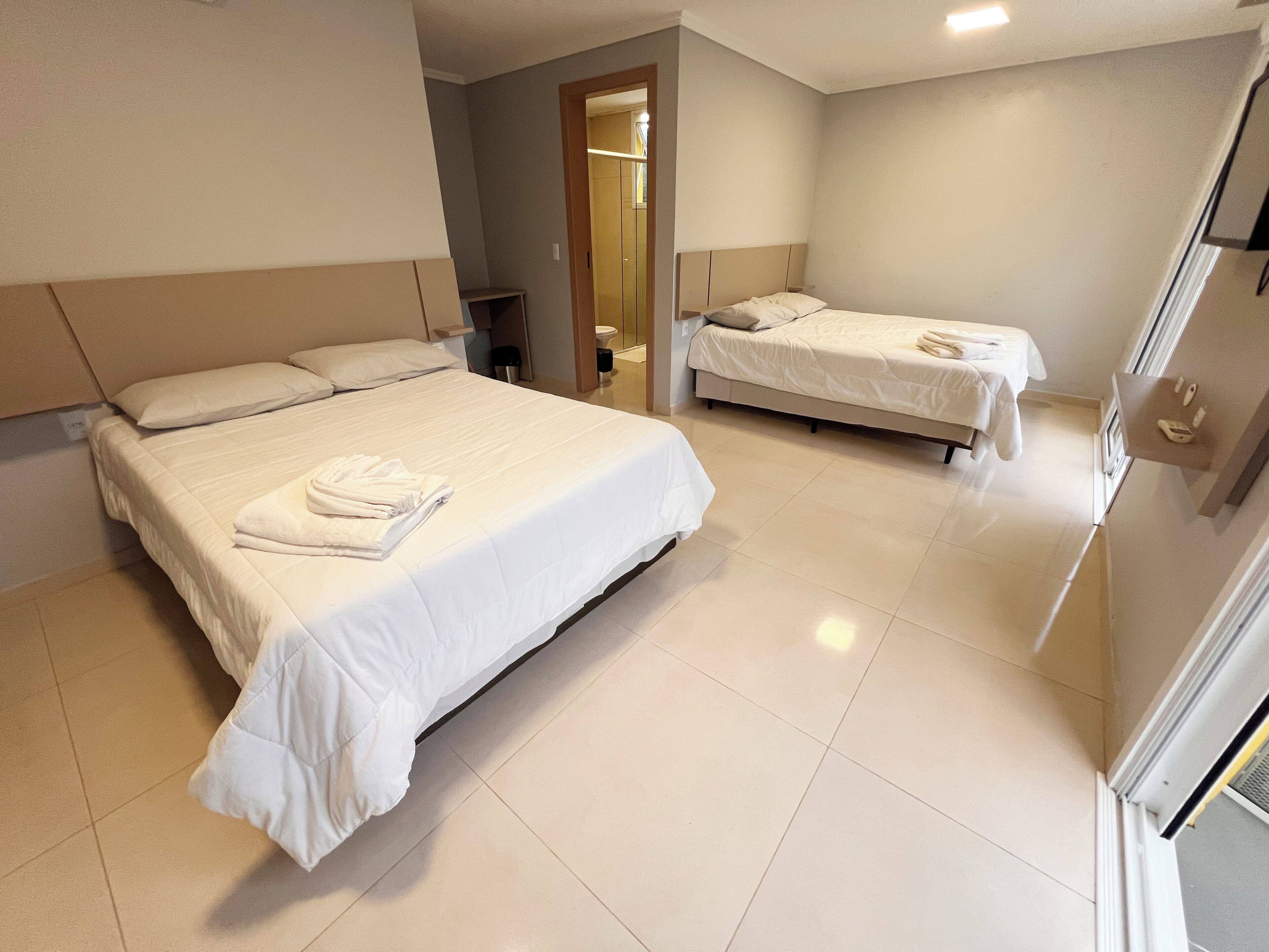 Une chambre d’hôtel avec deux lits, une salle de bain et une vue sur l’extérieur.