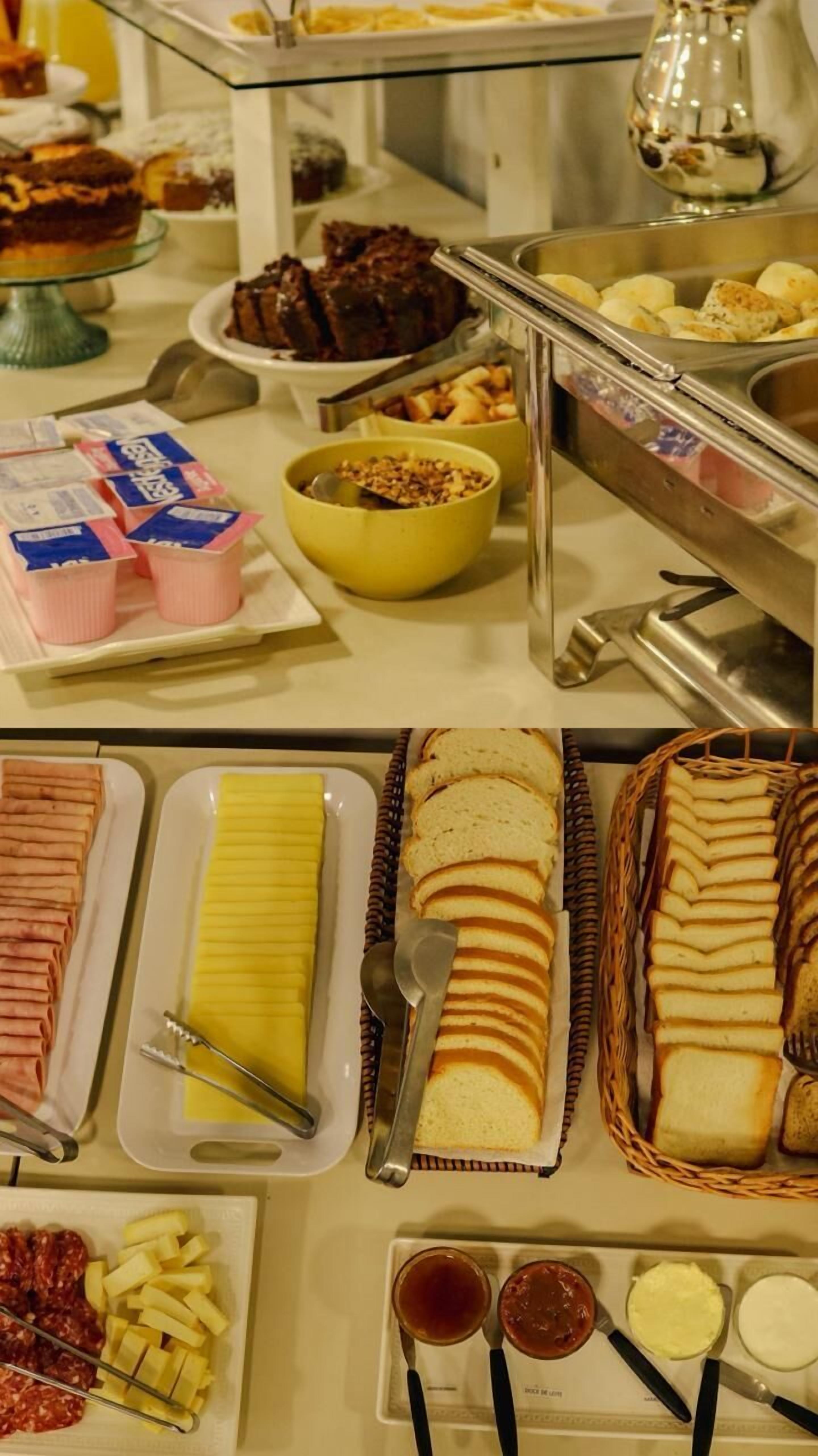 Een buffet met diverse gerechten, waaronder gebak, brood en toevoegingen.