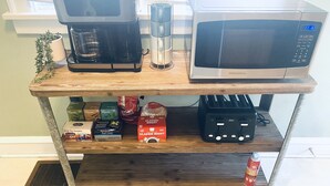 A kitchen shelf with a coffee maker, a microwave, and various food items. - King Suites - 2 King Beds & Garage Parking (Lakewood)