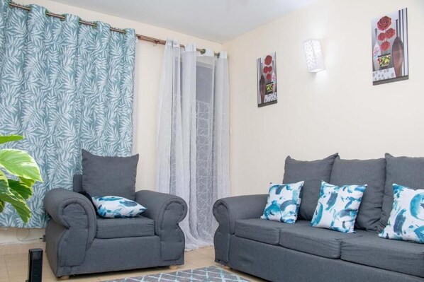 Business Apartment | Living area | 24-inch Smart TV with digital channels, TV - Stay.Plus Royale Village Apartment (Syokimau)
