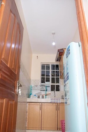 Business Apartment | Private kitchen | Fridge, cookware/dishes/utensils - Stay.Plus Royale Village Apartment (Syokimau)