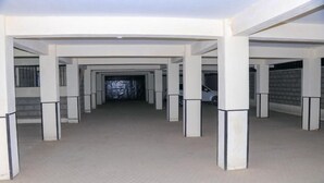 A covered parking area with multiple columns and a central walkway. - Stay.Plus Royale Village Apartment (Syokimau)
