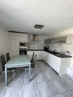 Enjoy cooking in this well-equipped kitchen with a central island, oven, and stainless steel range hood.