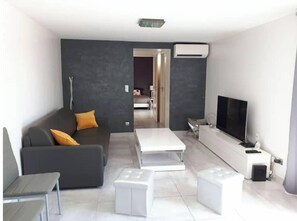Relax in this stylish living space with a sofa, coffee table, and TV.