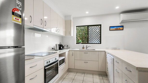 A modern kitchen with stainless steel appliances, a window with a view, and a clean, minimalist design. - Bell Street 36, Dicky Beach (Dicky Beach)