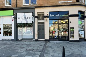 A storefront with 'allure' and 'Scotmid co-operative' signs, a closed door, and a Warrender Park sign.