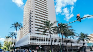 A tall hotel with a flat facade, multiple balconies, and a distinctive white fence at the base. - Ocean & Iconic Waikiki Views from the Marine Surf by the Beach w/Full Kitchen (Honolulu)