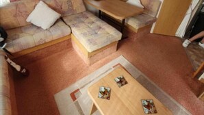 A cozy living area with a sofa set, a wooden coffee table, and a small table with decorative items.