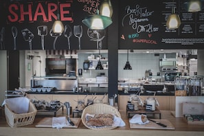 A breakfast bar with bread, pastries, and condiments.
