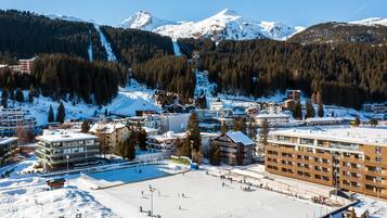 Eine verschneite Stadt mit Skipiste, Gebäuden und einer großen Freifläche.