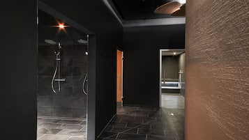 Experience a serene bathroom retreat with a glass-enclosed shower, handheld showerhead, and towel rack.
