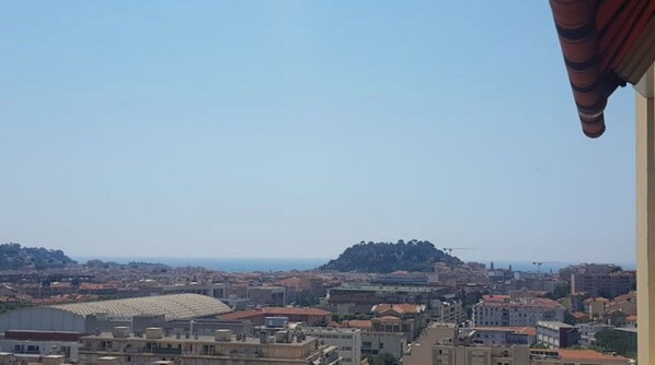 A cityscape with a prominent hill in the background, a stadium, and various buildings.
