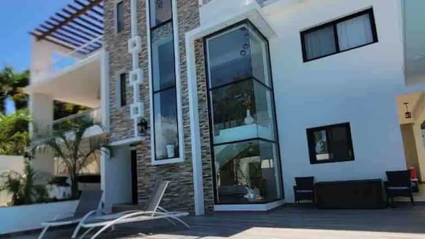 A modern two-story house with a swimming pool, a covered outdoor seating area, and a stone facade. - Luxury Apt w/ Pool 5-min Walk to Beach & Ocean World (Cofresi)