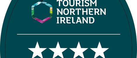 A badge with the text "TOURISM NORTHERN IRELAND" and "Self Catering" along with four stars.