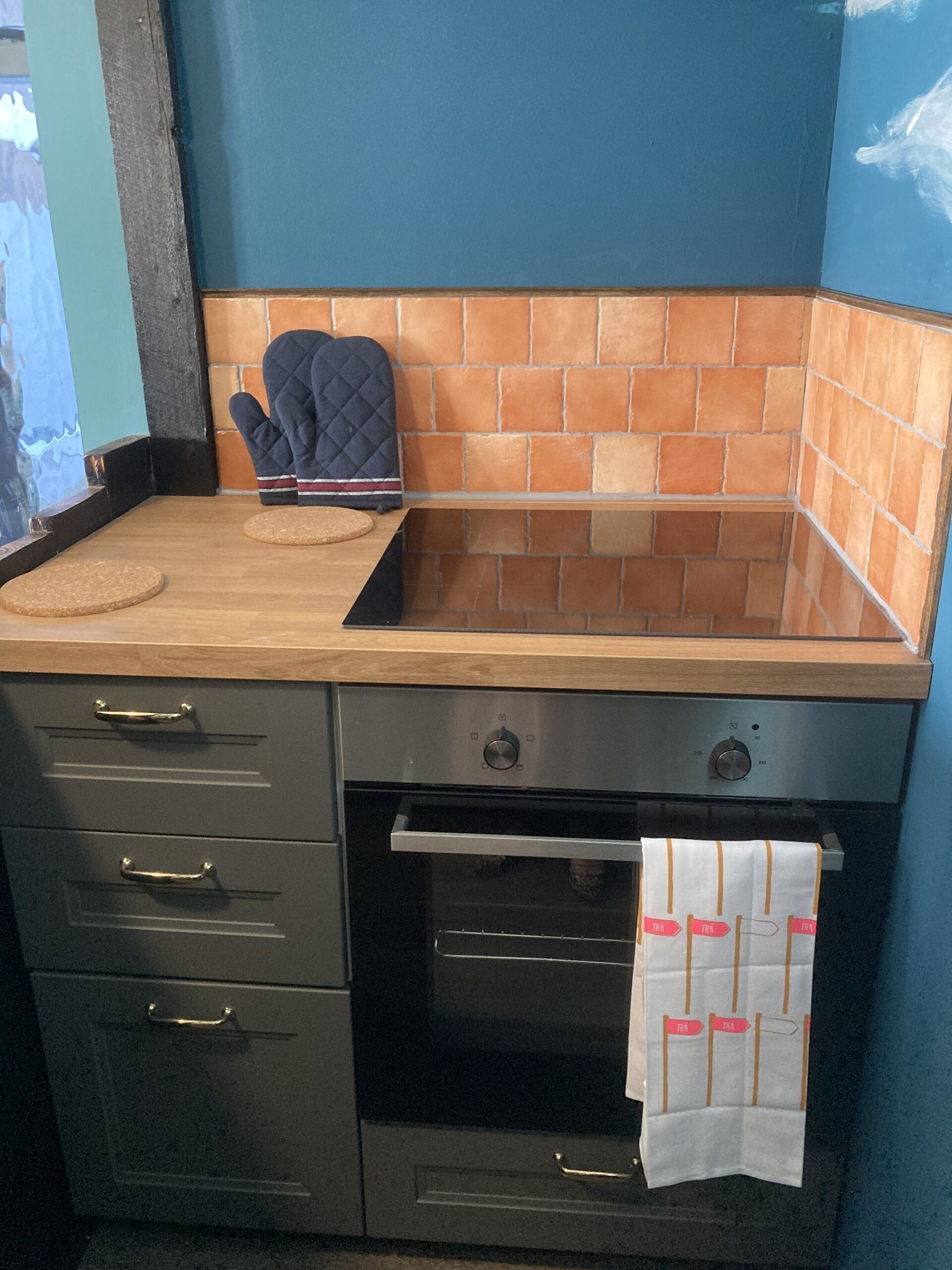 A kitchen with a wooden countertop, a built-in oven, and a tiled backsplash.