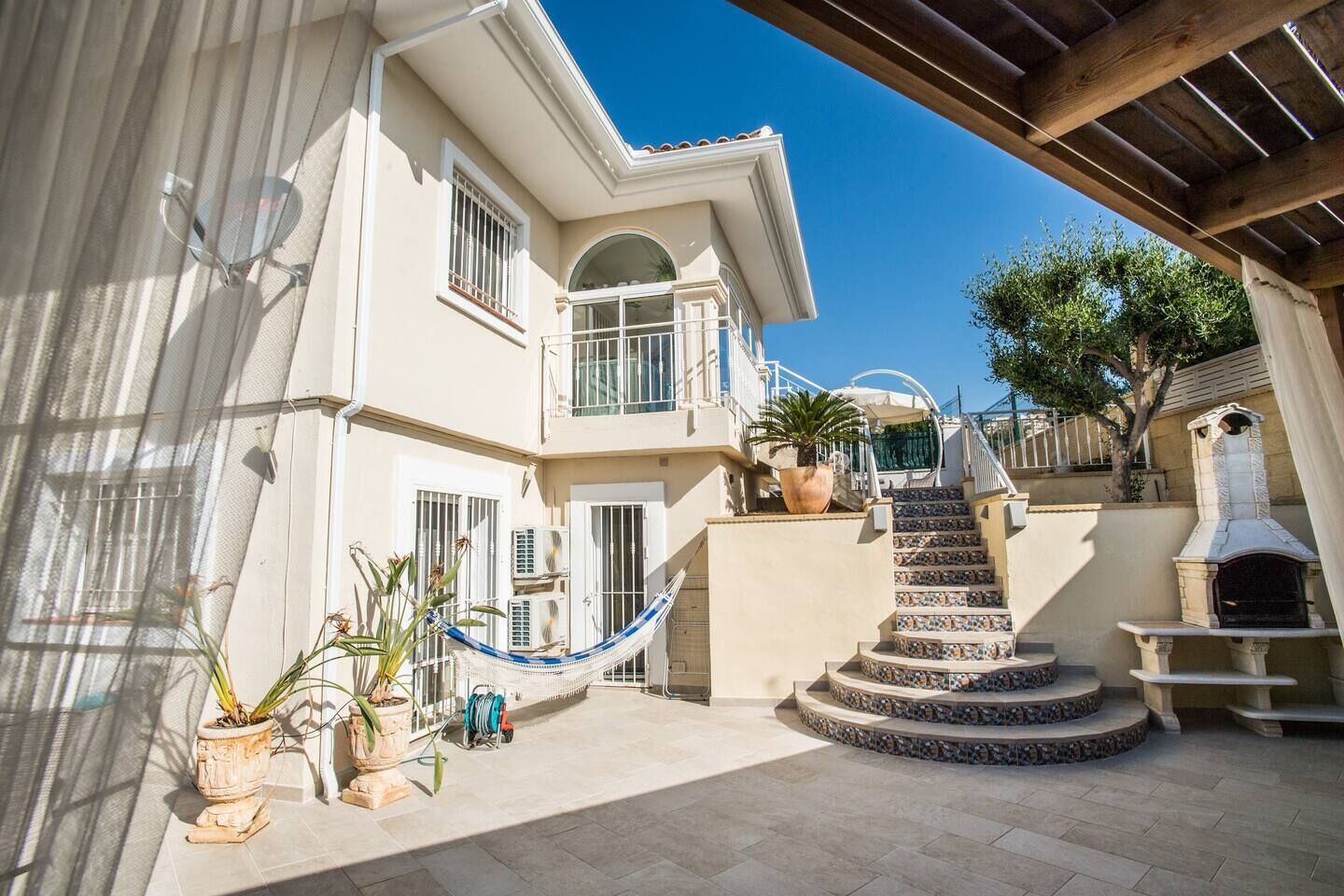 Ein zweistöckiges Gebäude mit Balkon, Wendeltreppe und Kamin aus Stein.