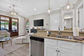 A modern kitchen with a dishwasher, granite countertops, a sink, and a built-in oven. - Bama Getaway - Walk to Downtown & Campus!  Luxurious and cozy furnishings! (Tuscaloosa)