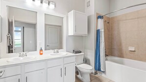 Une salle de bain moderne avec un meuble-lavabo à deux vasques, des toilettes et une baignoire.