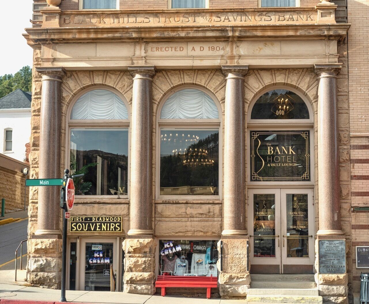 Ein historisches Gebäude mit einer Schilder für 'Black Hills Trust & Savings Bank' und 'Bank Hotel & Vault Lounge'.