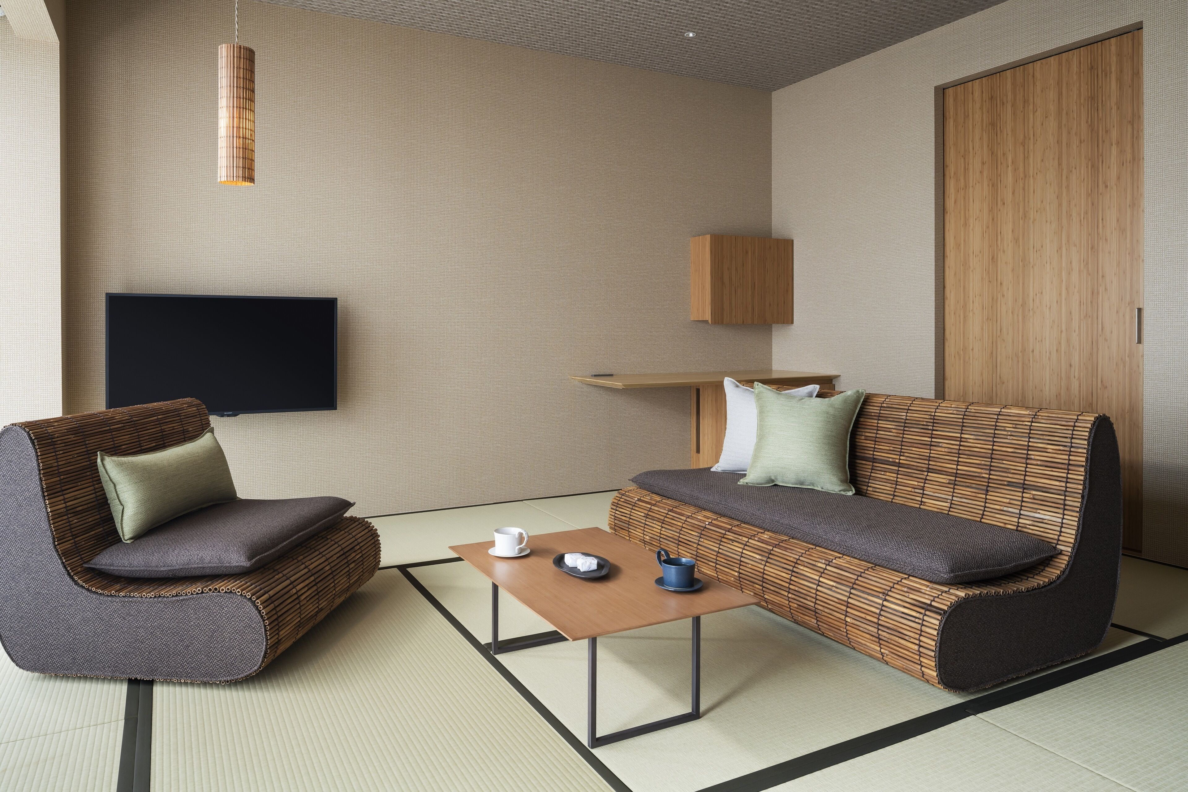 A modern living room with a sofa, armchair, and a small table with a tray.