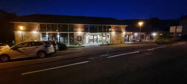 Un edificio con fachada de piedra, ventanas amplias y un cartel que dice 'Motel Service'.