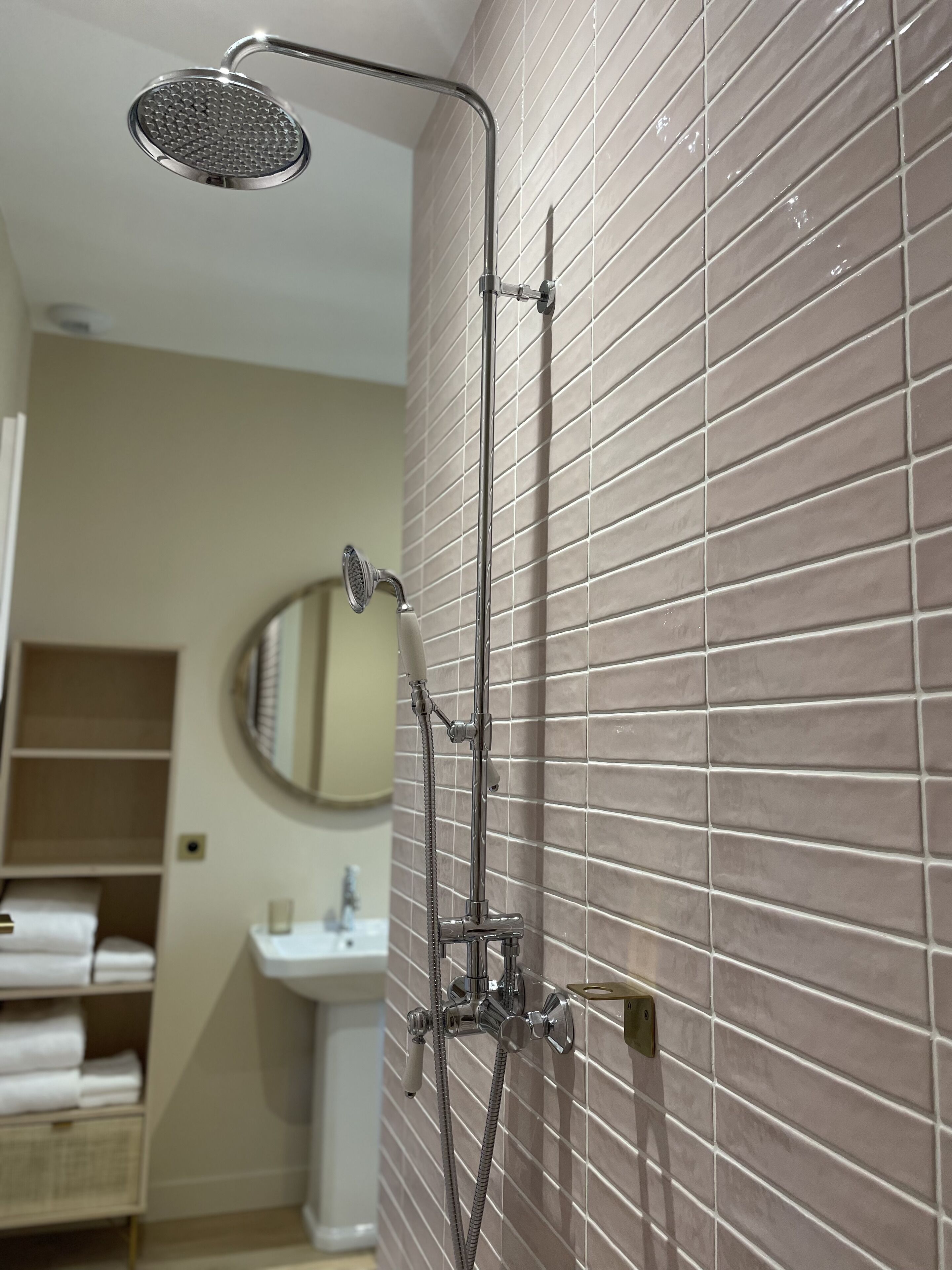 A bathroom with a shower, a sink, and a mirror.