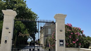 Uma entrada protegida por grades, com um caminho bem definido que leva a um edifício.