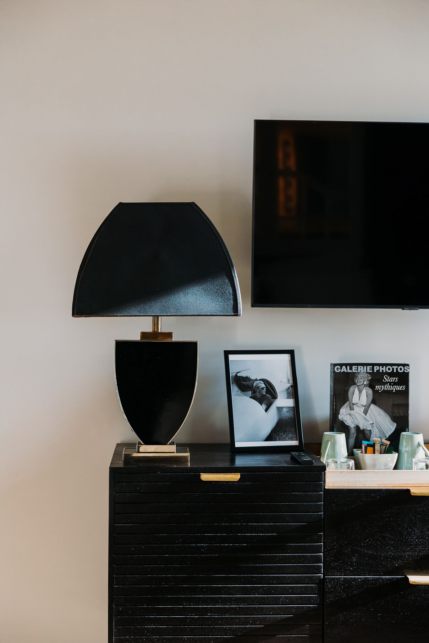 A black desk with a lamp, a framed photo, and a magazine titled 'Galerie Photos'.