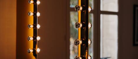 A mirror with lights around its edge, likely for a dressing room.