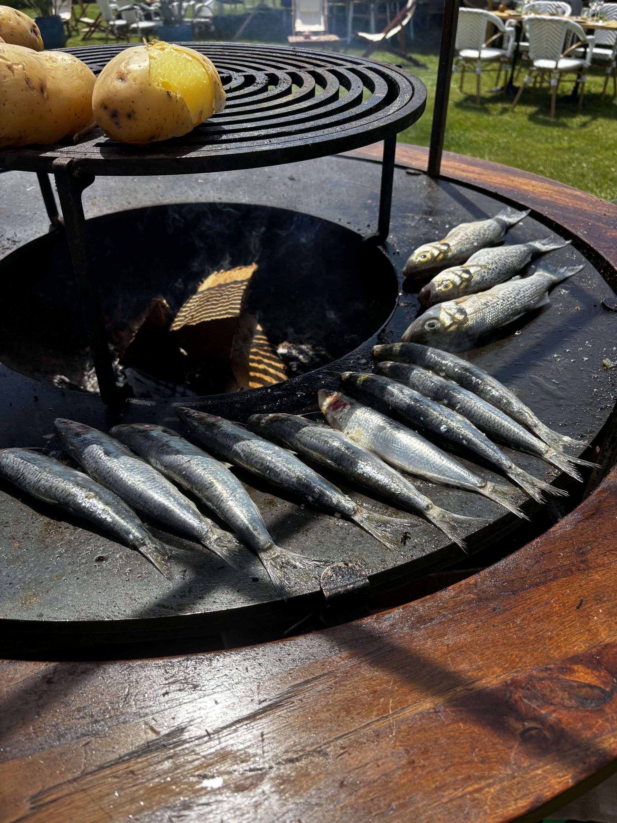A grill with fish and potatoes.