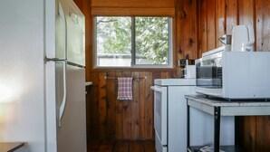 A compact kitchen with wooden walls, a refrigerator, a microwave, and a coffee maker. - Muskoka Cabin on Little Lake Port Severn (Port Severn)