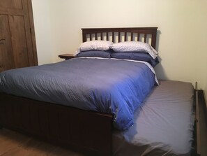 Un lit avec une tête de lit en bois, une table de chevet et une armoire en bois.