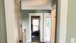 A hallway with a dark wooden floor, white walls, and a white door on the left. - Cute cozy apartment. Half a block walking distance from beautiful downtown Ionia (Ionia)
