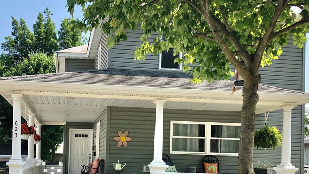 A house with a covered porch, a flower on the wall, and a brick pathway leading to the door. - Cute cozy apartment. Half a block walking distance from beautiful downtown Ionia (Ionia)