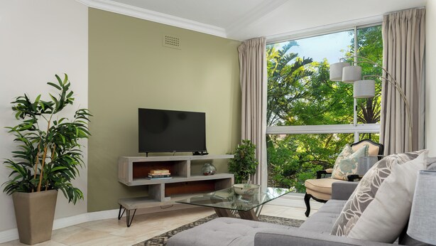 A living room with a sofa, a glass coffee table, a TV on a stand, and a large window with curtains. - Sonwyk 9 (Cape Town)