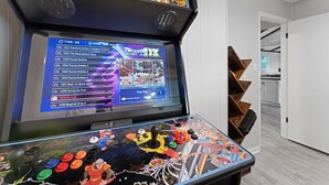 Videopelikahvila, jossa on useita peliautomaatteja ja niiden näytöillä esitellään valikoima pelejä, kuten esimerkiksi pelit ”PANDORA DX SAGA RUS” ja ”1521 Puzzle & Action 2”.