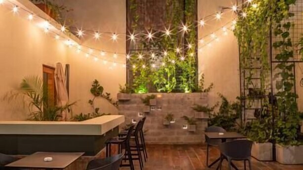Um restaurante acolhedor com piso de madeira, balcão e várias mesas e cadeiras.