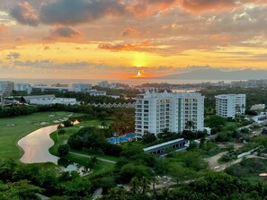 Stunning resort area with a large lake, golf course, and modern buildings with balconies.