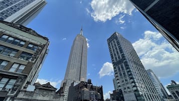Un paisaje urbano con edificios altos, incluyendo un rascacielos destacado con aguja, rodeado de otras estructuras elevadas.