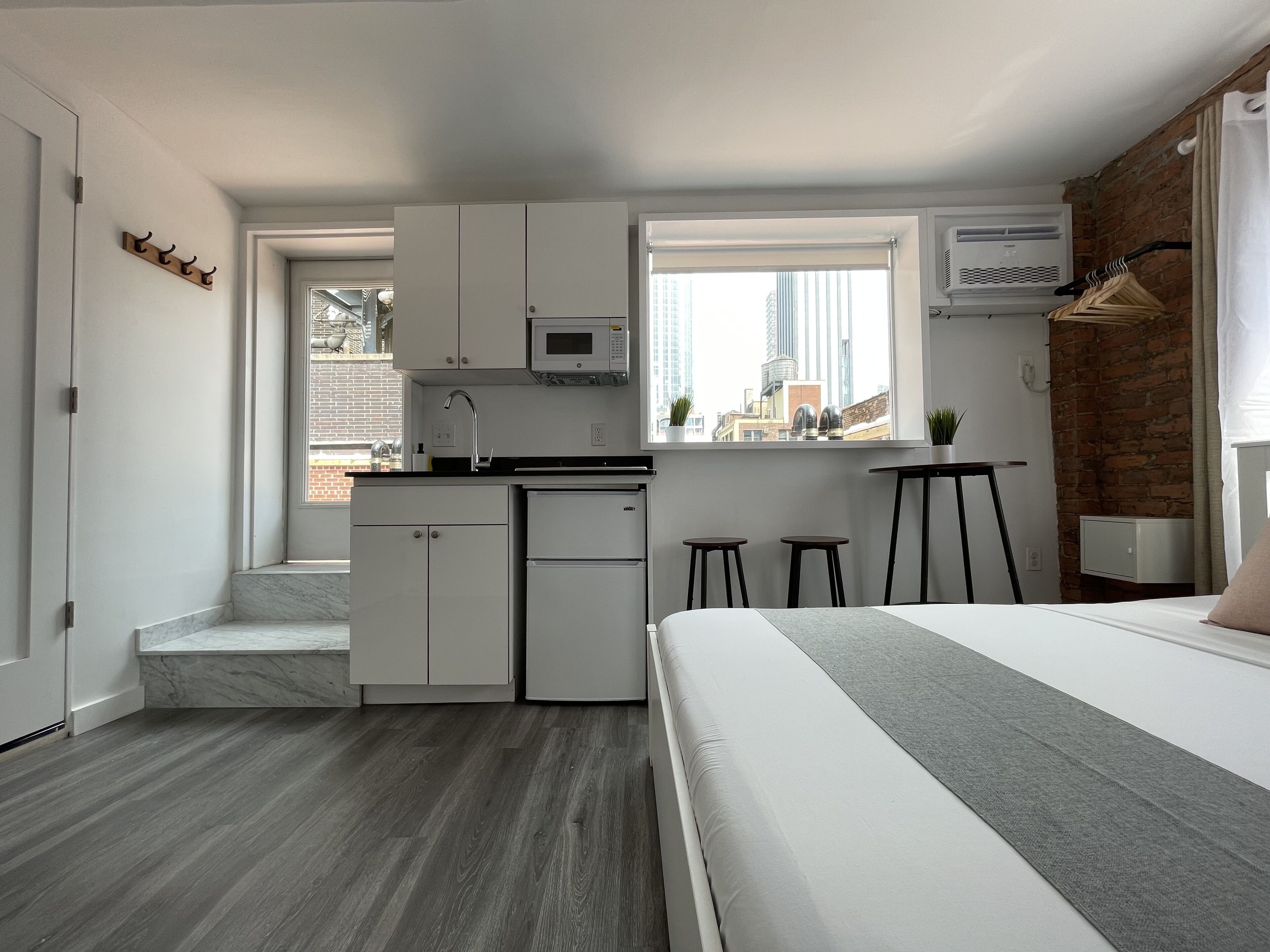 Una cocina compacta con microondas, un fregadero y una ventana con vistas a la ciudad.