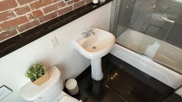 A modern bathroom with a toilet, sink, and bathtub.